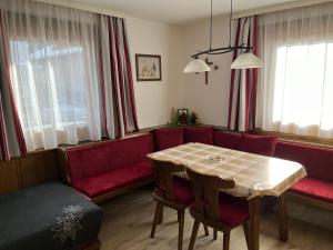 a living room with a table and a red couch at Ferienwohnung Höllwarth in Gerlos