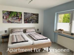 een slaapkamer met een bed en twee schilderijen aan de muur bij Ferienwohnung Zenzen in Cochem