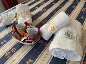 1 cama con 2 toallas, tazas y calcetines en AFFITTACAMERE ALLE ALPI, en Malborghetto Valbruna