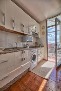 a kitchen with a sink and a washing machine at Amaoré, paz, hogar y playa in Alajeró