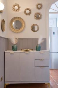 a kitchen with white cabinets and a refrigerator and mirrors at Amaoré, paz, hogar y playa in Alajeró