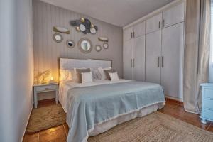 una camera da letto con un grande letto bianco e uno specchio di Amaoré, paz, hogar y playa ad Alajeró