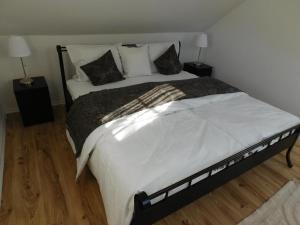 a bedroom with a large bed with white sheets and pillows at Lea in Samobor