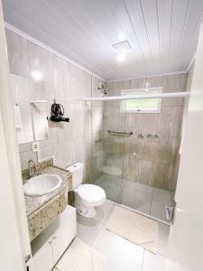 uma casa de banho com um chuveiro, um WC e um lavatório. em Pousada do Bosque Bento em Bento Gonçalves