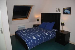 een slaapkamer met een bed met blauwe lakens en een raam bij Location Golfe du Morbihan in Arradon