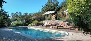 uma piscina com duas cadeiras e um guarda-sol em Casa Vesta Mar em San Antonio