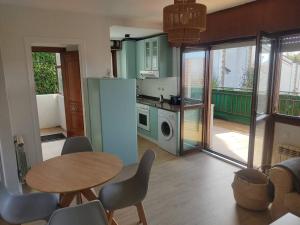 eine Küche mit einem Tisch und Stühlen sowie einem Kühlschrank in der Unterkunft Apartamento en Mogro. in Mogro