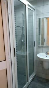 a bathroom with a glass shower and a sink at Quaint Studio apartment in Birgu