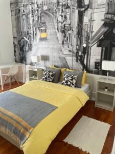 1 dormitorio con cama amarilla y mural en la pared en Quarto com varanda em Arroios 1, en Lisboa