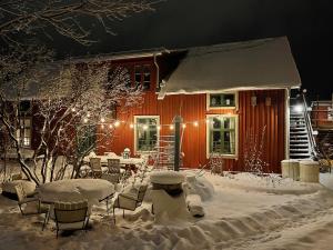 a house covered in snow at night with lights at Lilla Hotellet in Tranemo
