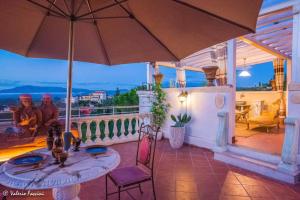 a patio with a table and an umbrella on a balcony at HomArt roof roman king in Borghesiana 