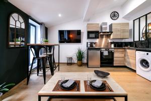 Appartement “L’industriel” plein centre historique في بيربينيا: مطبخ وغرفة معيشة مع طاولة وأدوات