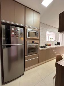 a kitchen with a stainless steel refrigerator and a microwave at Apartamento familiar no centro em Nova Friburgo in Nova Friburgo