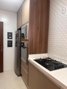 a kitchen with a stove and a refrigerator at Apartamento familiar no centro em Nova Friburgo in Nova Friburgo