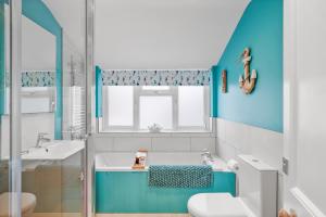 a blue and white bathroom with a sink and a toilet at 3 - Bed Spacious Luxury Townhouse, Great for Contractors & Groups l Sleeps 6 with Free Parking - Blue Puffin Stays in Portsmouth