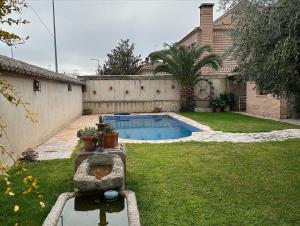 a backyard with a swimming pool in a yard at La Flor del Granado in Torrijos