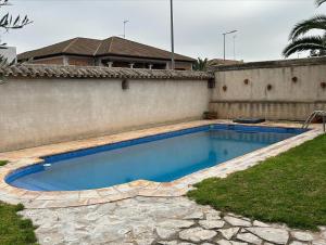 a swimming pool in front of a house at La Flor del Granado in Torrijos