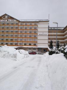 a snow covered street in front of a hotel at Apartman MARLEA in Donovaly