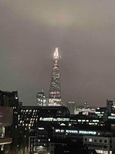 a tall building lit up at night in a city at Skyline View - City of London. in London