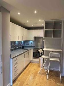 a kitchen with white cabinets and a table and chairs at Skyline View - City of London. in London