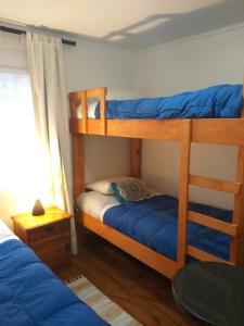 1 dormitorio con 2 literas con sábanas azules en Cabanas Vista Mar, en San Antonio