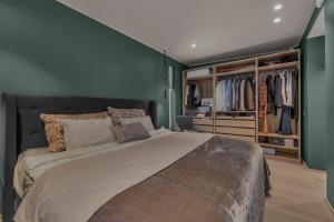 a bedroom with a large bed with green walls at Villa Aurora View in Tromsø