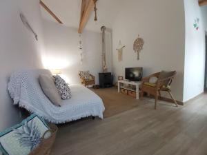a living room with a bed and a tv at Casas do Patheo in Óbidos