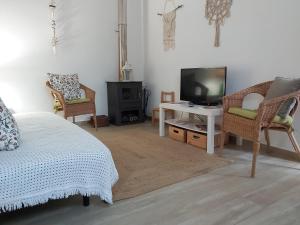 a living room with a bed and a tv and chairs at Casas do Patheo in Óbidos +32 photos