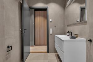 uma casa de banho com um WC, um lavatório e uma porta em Villa Aurora View em Tromsø