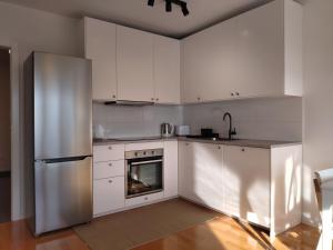 uma cozinha com armários brancos e um frigorífico de aço inoxidável em 2 Bedroom Apartment Lili em Zagreb