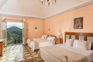 een hotelkamer met 2 bedden en een balkon bij Il Vescovo, Incredible Attic in center of Montepulciano, Luxe in Montepulciano