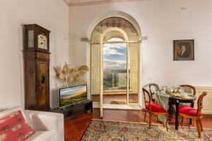 een woonkamer met een tafel en een televisie bij Il Vescovo, Incredible Attic in center of Montepulciano, Luxe in Montepulciano