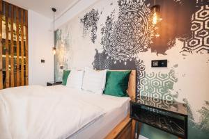 a bedroom with a white bed and a black and white wall at A Guesthouse Sibiu in Sibiu