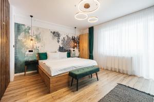 a bedroom with a bed and a green bench in it at A Guesthouse Sibiu in Sibiu
