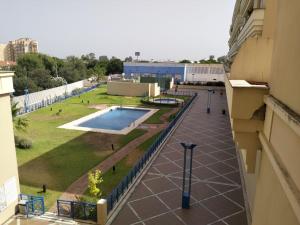 einen Blick vom Balkon eines Gebäudes mit Pool in der Unterkunft Estudio Lux-Palacio de Congresos in Sevilla