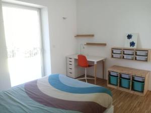 Schlafzimmer mit einem Bett, einem Schreibtisch und einem Stuhl in der Unterkunft Casa moderna julio y agosto in Ferrol