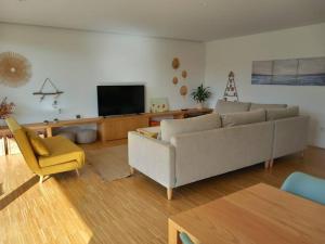 a living room with a couch and a yellow chair at Casa moderna julio y agosto in Ferrol