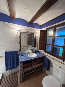 a bathroom with a sink and a toilet and a mirror at La Flor del Granado in Torrijos