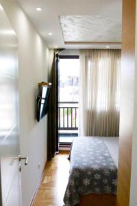 a bedroom with a bed and a window and a television at Apartman Bajka in Zlatibor
