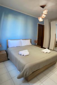 - une chambre avec un grand lit et 2 serviettes dans l'établissement Residence La Peonia, à Sassari