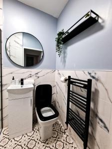 a bathroom with a mirror and a toilet and a sink at Cosy modern 1 Bedroom apartment! in Liverpool