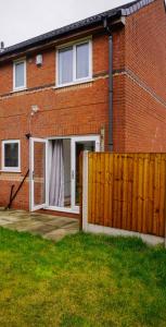 a red brick house with a sliding glass door at The Oasis in Wigan