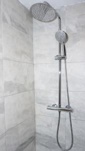 La salle de bains est pourvue d'une douche avec un pommeau de douche. dans l'établissement The Oasis, à Wigan