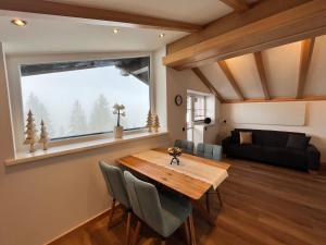 a living room with a wooden table and a large window at Appartements Zahnleiten in Untertauern