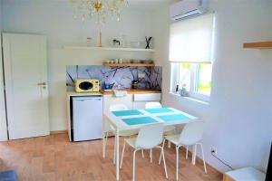 a kitchen with a table and chairs and a microwave at Modrý apartmán 1 in Znojmo +4 photos