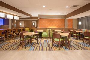 a restaurant with tables and chairs and a chalkboard at Fairfield Inn & Suites by Marriott Burlington in Burlington