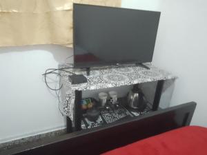 a tv sitting on a stand with a table at Trinidad Hostal in San Salvador de Jujuy