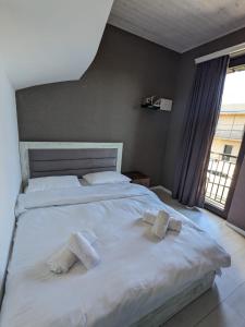 1 dormitorio con 1 cama blanca grande y toallas. en Guesthouse Chrdili, en Tiflis