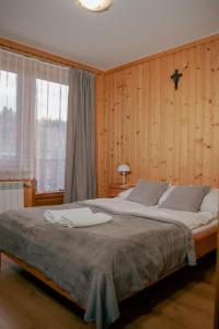 um quarto com uma cama grande e uma cruz na parede em Pokoje Gościnne Bożena Dunajczan em Brzegi