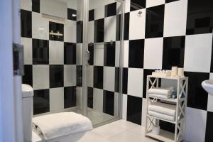 a bathroom with a black and white checkered wall at BeachMirissa Hotel in Mirissa +21 photos